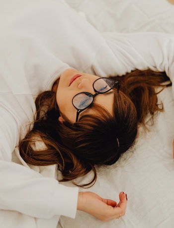 Das Bild zeigt eine Frau, die auf dem Bett liegt.